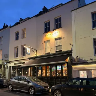 Photo of a building with a publican sign of a squirrel wearing a crown, with 'Royal Oak' written below it.